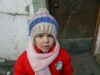 Four-year-old Vika stands by the door of her house in Krasnohorivka, Donetsk region. Vika often comes to the front yard waiting to see the snow. The girl likes sledding and to build a snowman.